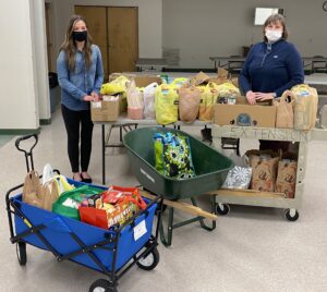 Social Worker and FCS agent standing with donated food.