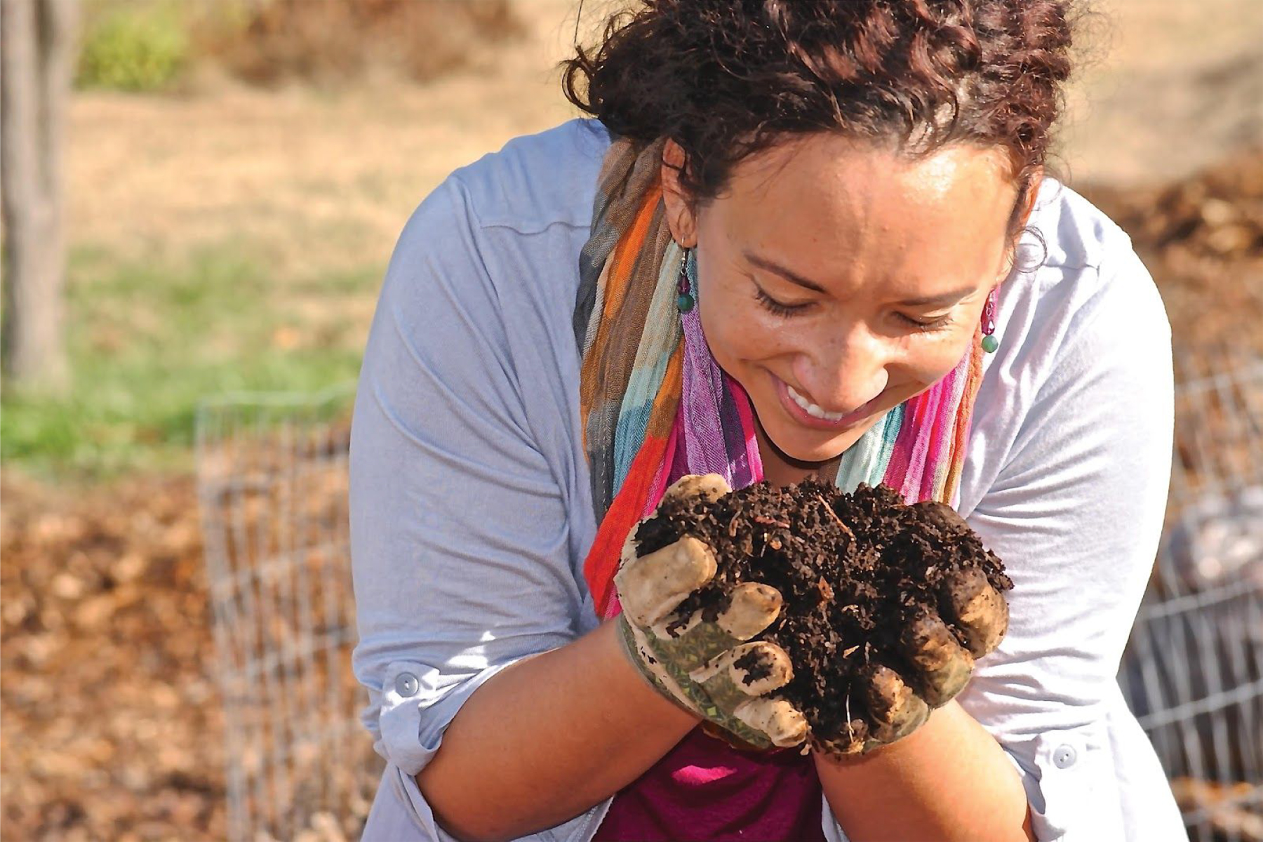 Gardener with soil in hands smiling